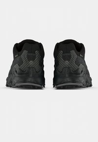 Ténis de corrida pretos com um acabamento texturizado, sola robusta e parte superior em malha para respirabilidade, com um padrão geométrico nos detalhes do calcanhar.