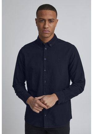 Navy long-sleeve button-down shirt made of cotton, featuring a collar, purple buttons, and a small logo on the chest.