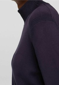 Marineblauwe trui met een hoge geribbelde kraag, voorzien van gestructureerde details op de schouders en een glad gebreide stof.