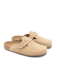 Beżowe zamszowe klapki wsuwane z okrągłym noskiem, przednim paskiem i regulowanym zapięciem, z korkową wkładką i gumową podeszwą.