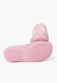 Zapatillas rosas hechas de material de felpa con una textura suave, forma redondeada y suela de goma con un patrón de agarre texturizado.