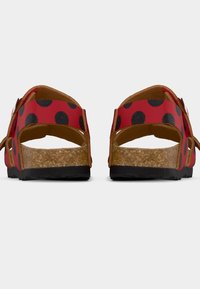 Κόκκινα σανδάλια με μαύρα πουά και φελλό σόλα. Διαθέτουν σχεδιασμό με δύο λουριά και ανοιχτή πλάτη για αερισμό. Υφή στη σόλα για καλύτερη πρόσφυση.