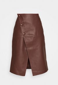 Ruskea nahkainen kietaisuhame, jossa on kolmionmuotoinen leikkaus, kolme koristeellista nappia vasemmalla puolella ja keskipitkä malli, jossa on hillitty halkio.