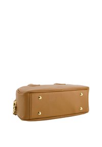 Tan leather handbag with a structured shape, featuring gold hardware and four metal feet on the bottom for stability. Textured surface.