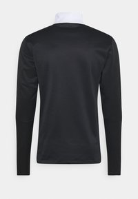 Czarna bluzka z długim rękawem z białym kołnierzykiem, wykonana z g�ładkiego materiału. Posiada minimalistyczny design bez widocznych logo czy wzorów.