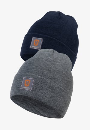 Deux bonnets en tricot : l'un bleu marine et l'autre gris. Chacun a un rebord replié et une étiquette rectangulaire orange et grise avec "JEANSCODE". Texture douce.