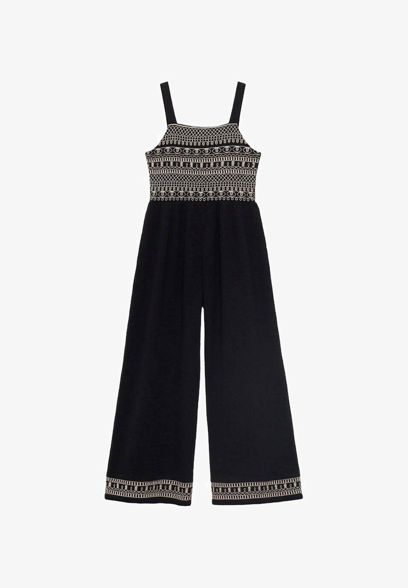 Combinaison noire à jambes larges avec fines bretelles, ornée de broderies géométriques blanches sur le corsage et l'ourlet.