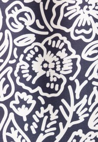 Tessuto floreale con disegni di linee bianche su uno sfondo blu navy scuro, con intricate incisioni di fiori e foglie, texture liscia e senza hardware visibile.