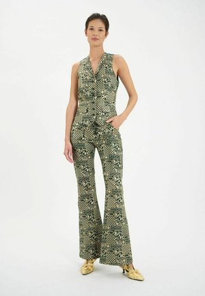 Une combinaison à motifs verts avec un haut ajusté et des jambes évasées, présentant divers motifs géométriques et abstraits en beige.