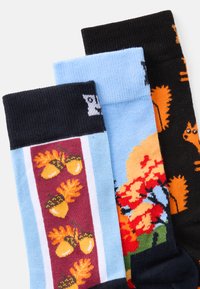 Tre par sokker: blå med eikenøtter, livlig blomsterdesign, og svart med oransje ekorn. Strikkede mønstre, ribbede mansjetter.