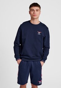Navyblauwe sweatshirt met geribde manchetten en zoom, met een klein logo op de borst. Gepaarde met bijpassende shorts, beide van zachte stof.