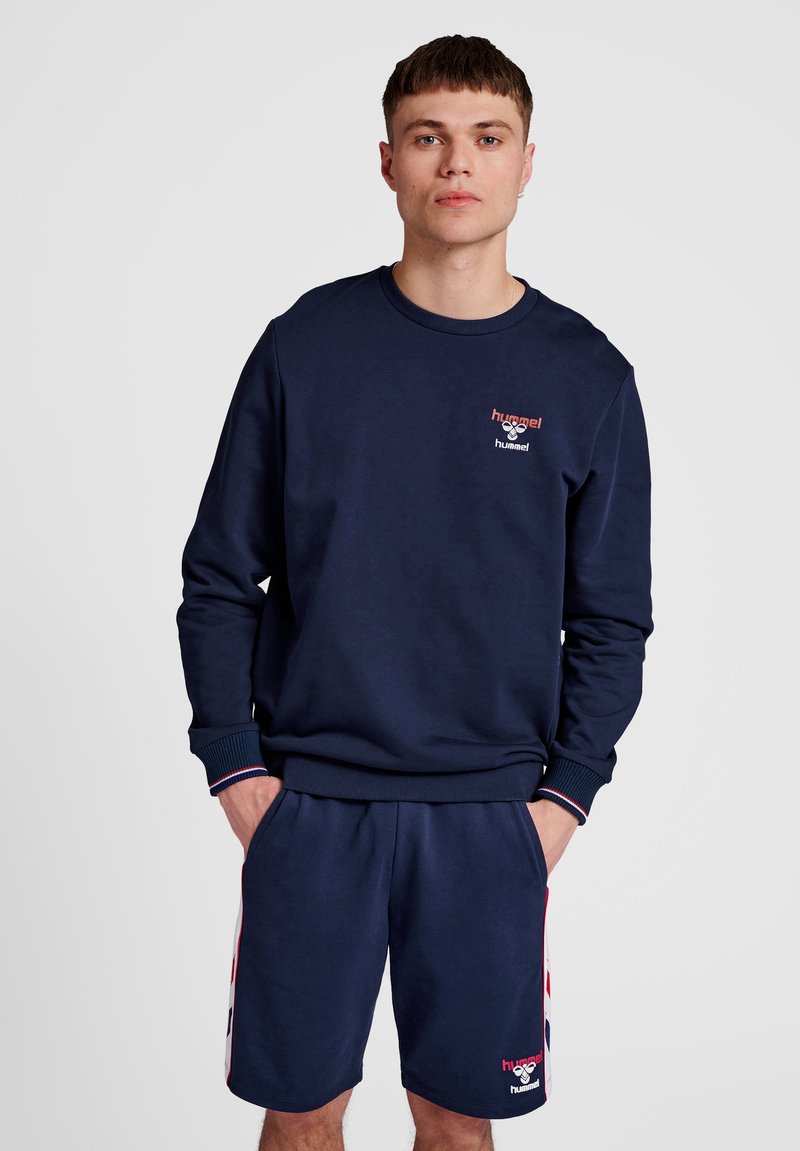 Navyblauwe sweatshirt met geribde manchetten en zoom, met een klein logo op de borst. Gepaarde met bijpassende shorts, beide van zachte stof.