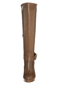 Botas de cuero sintético marrones, hasta la rodilla, con puntera redonda, cremallera lateral y un detalle de correa en el tobillo con acentos de hardware. Textura suave.