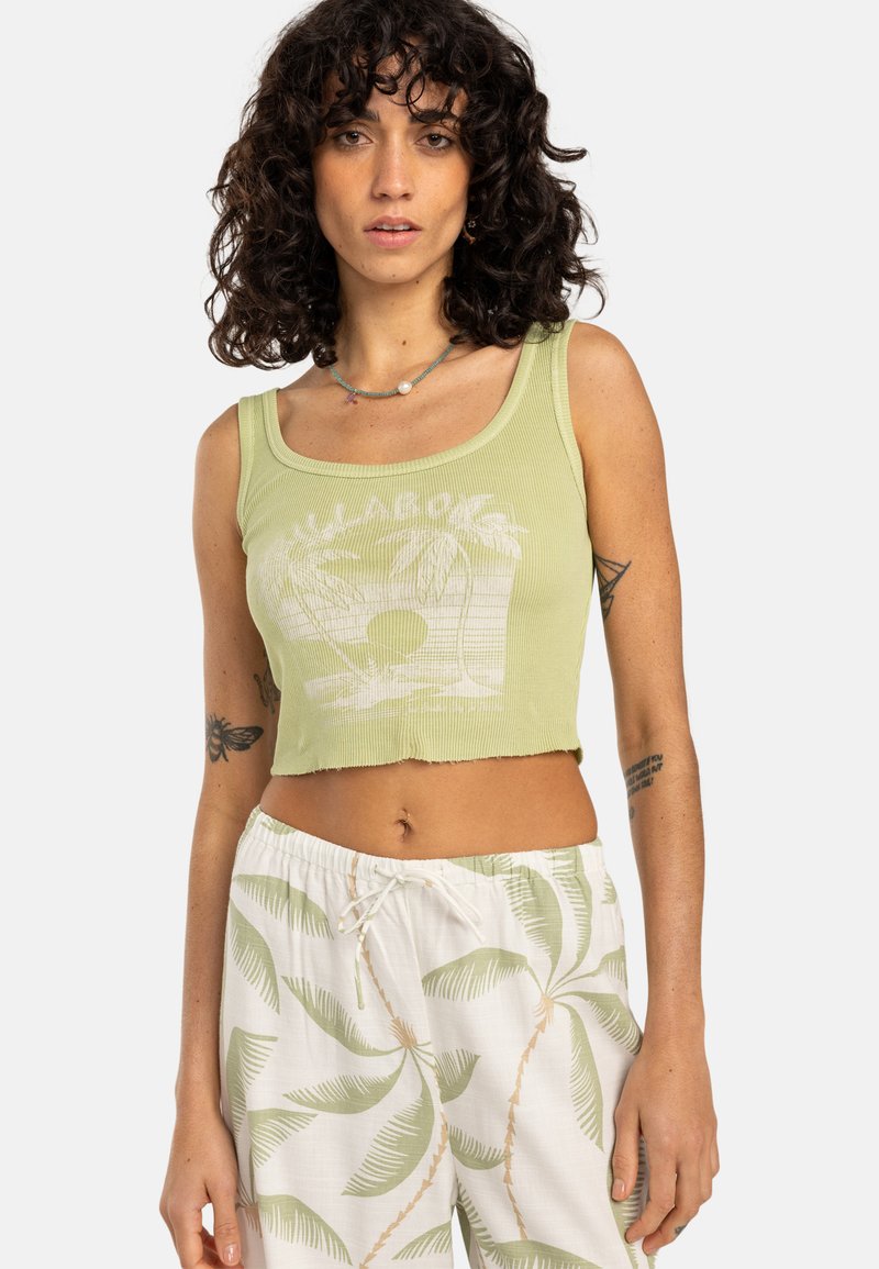 Light green ribbed crop top with white palm tree graphic. Paired with white pants featuring green palm leaf patterns and drawstring waist.