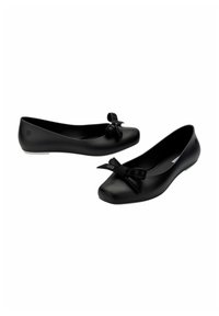 Czarne płaskie buty wykonane z matowego materiału, z zaokrąglonym noskiem i teksturalnym czarnym akcentem w postaci kokardy z przodu. Gładki design powierzchni.