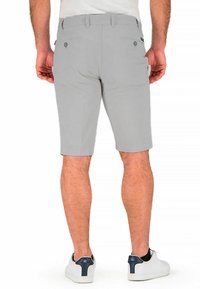 Gray shorts made of a lightweight material, featuring two back pockets with button closures and a straight cut, worn with white sneakers.