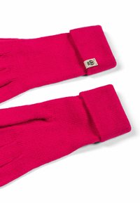 Helle pink gestrickte Handschuhe mit umgeschlagenen Bündchen und einem kleinen beigen Etikett mit einem schwarzen Logo an einem Bündchen, flach auf einer weißen Oberfläche ausgelegt.