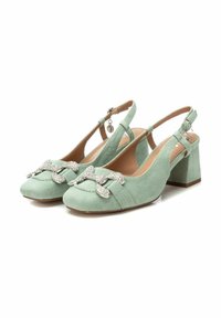 Zapatos de tacón slingback de ante verde menta con un tacón ancho, punta redonda y un lazo metálico adornado con rhinestones claros.