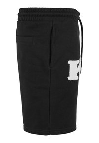 Black cotton shorts with an elastic waistband, side pocket, and a white raised letter "K" detail on the thigh.