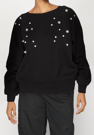 Sudadera negra con un escote amplio y mangas largas, adornada con embellishments de perlas y cristales en la parte delantera y los hombros.
