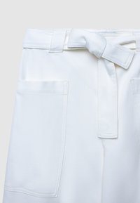 Shorts bianchi a vita alta con cintura annodata, due tasche frontali e una texture liscia, progettati per una vestibilità strutturata.
