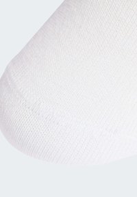 Λευκή κάλτσα με υφαντό μοτίβο υφής, που εμφανίζει κοντινή λήψη με έμφαση στο λείο ύφασμα και το αδιάβροχο σχέδιο στο δάχτυλο.