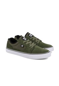 Green suede sneakers with a canvas toe and black accents, featuring white rubber soles and laces. Logo displayed on the side.