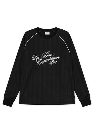 Chemise noire à manches longues avec passepoil blanc sur les épaules et texte en cursive blanc "Les Deux Copenhagen 2011" au centre devant.