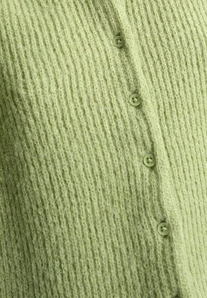 Tissu en maille côtelée vert clair avec quatre petits boutons assortis alignés verticalement.