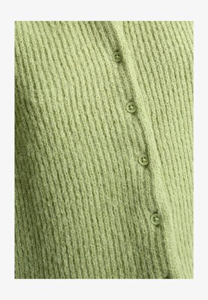 Tissu en maille côtelée vert clair avec quatre petits boutons assortis alignés verticalement.