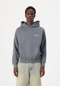 Grijze hoodie met een voorzak, ribbelboorden en een verstelbare capuchon. Bevat een klein wit logo op de borst. Casual, relaxte pasvorm.