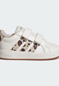 Sneaker bianca con due strisce in velcro, con accenti di stampa leopardata sui lati, suola in gomma e tomaia texturizzata con una fodera morbida.