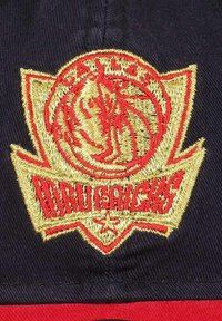 Dallas Mavericks cap featuring a navy fabric with gold and red embroidery. The design includes a prominent logo and sharp, triangular detailing.