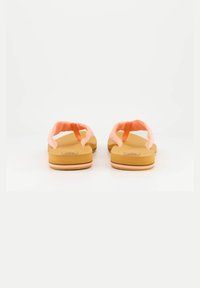 Pink flip-flops with textured straps, tan soles, and subtle striped accents on the edges. Designed for casual wear and comfort.