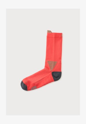 Une chaussette unique orange vif avec un bout et un talon gris foncé, et des détails rayés marron au niveau de la cheville et des orteils sur fond blanc.