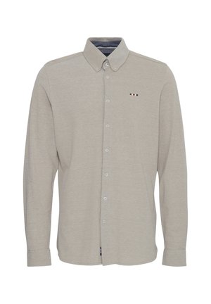 Világos bézs, hosszú ujjú gombos ing. Pamut keverék anyag, amely sima felületű. Képviseli a gallért és egy kis logó részletet piros, fehér és kék színekben.