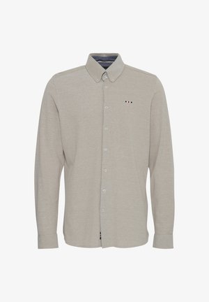 Világos bézs, hosszú ujjú gombos ing. Pamut keverék anyag, amely sima felületű. Képviseli a gallért és egy kis logó részletet piros, fehér és kék színekben.