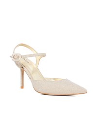 Beige high-heeled shoe with a pointed toe, covered in textured fabric, featuring a strap with a jewel-like buckle accent.