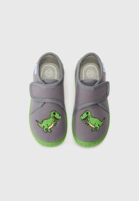 Grå stoffsko med grønne gummisåler; har en brodert grønn dinosaur på hver side og en borrelåsrem for lukkingen.