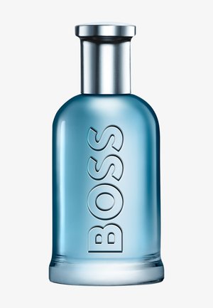 Niebieska szklana butelka perfum z srebrną nakrętką i wypukłym napisem „BOSS” pionowo z przodu.