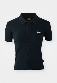 Kortärmad marinblå polo i mjukt, strukturerat tyg med knäppning fram och broderad logotyp på bröstet. Klassisk kragsdesign.