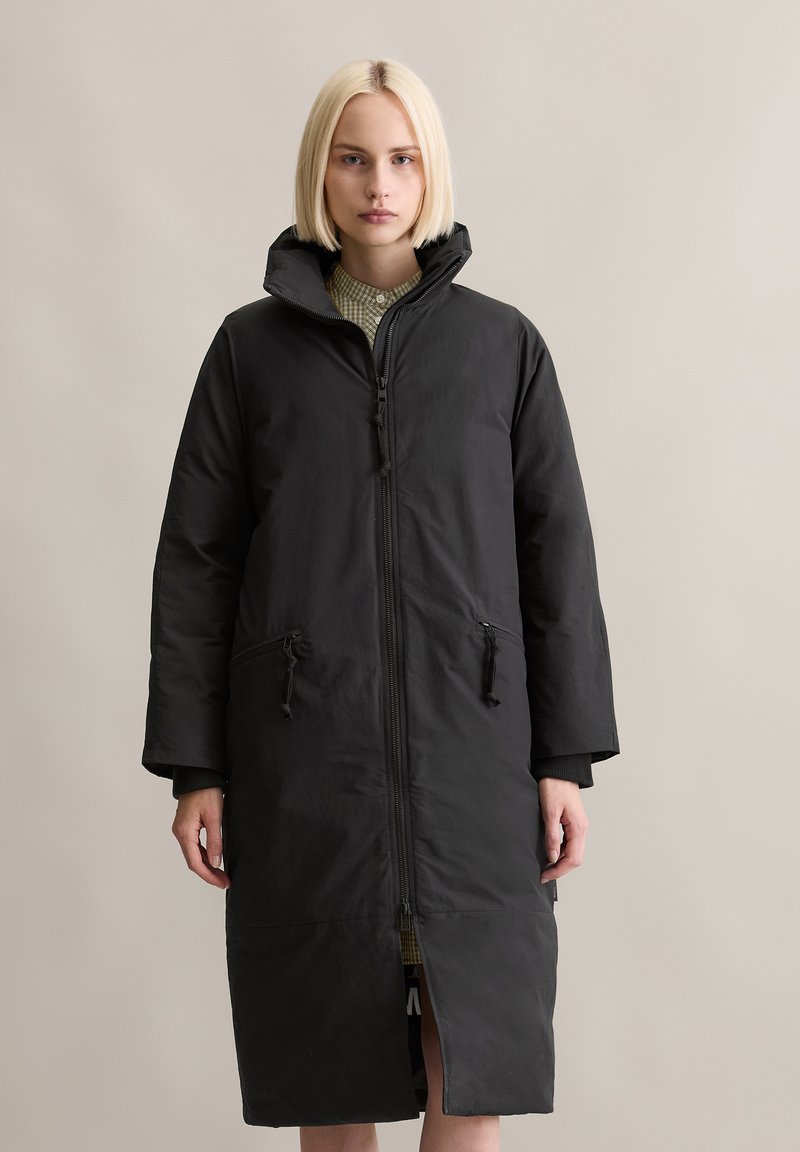 Schwarzer langer Mantel mit Reißverschluss vorne, Kapuze und Seitentaschen. Verfügt über eine glatte Textur und eine lockere Passform für zusätzlichen Komfort.