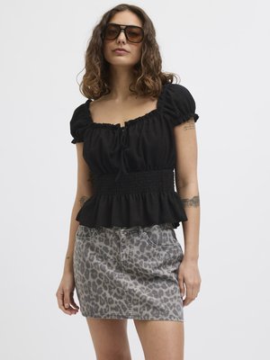 Top peplum nero con maniche a palloncino corte e dettaglio con nodo, abbinato a una mini gonna in denim grigio con stampa leopardata. Tessuto testurizzato e stile aderente.