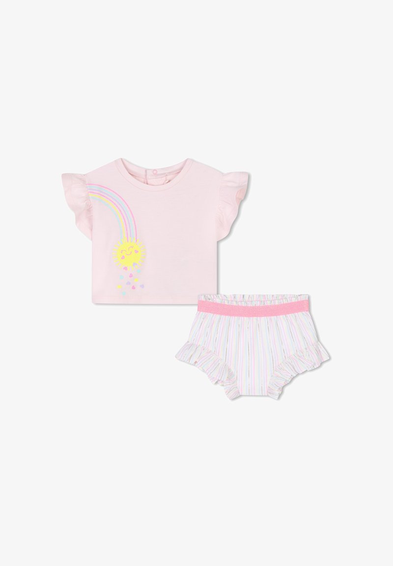 T-shirt rose à manches courtes avec des manches à volants, présentant un design de arc-en-ciel et de soleil. Shorts rayés assortis avec volants et une ceinture rose.