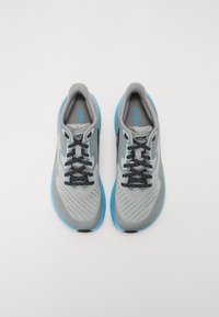 Baskets de sport grises avec une tige texturée, des accents bleus et des lacets noirs. Présentent un design léger et une forme de bout arrondie.