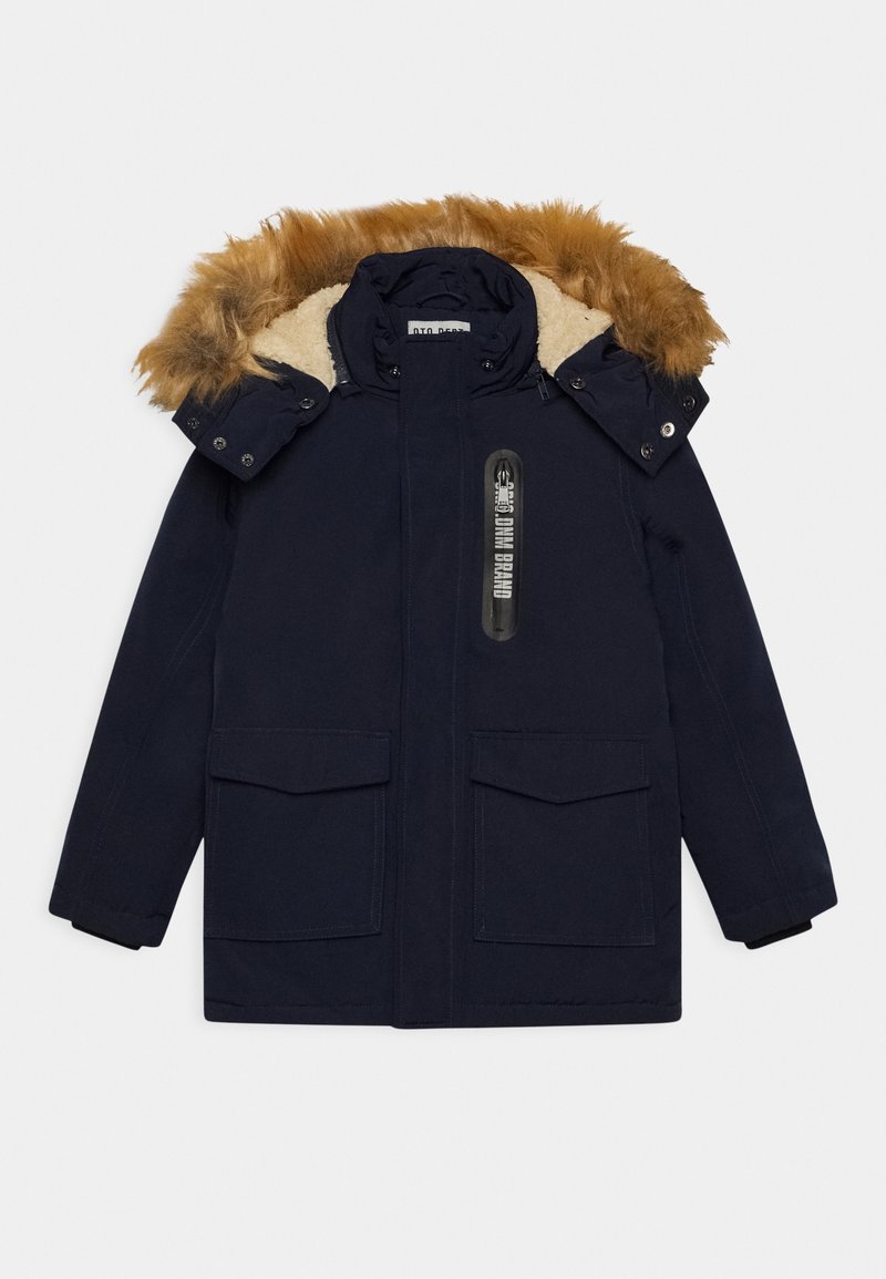 Parka de color azul marino con capucha forrada de piel sintética, dos bolsillos frontales y cierre frontal con cremallera. Presenta una marca en el pecho. Material cálido y duradero.