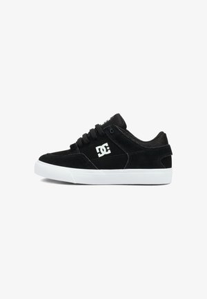 Czarne zamszowe buty do deskorolki z białą gumową podeszwą. Posiadają czarne sznurowadła oraz wyraźne białe logo po boku. Niskoprofilowy design.