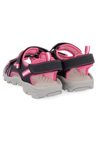 Sandales pour enfants noires et roses avec des sangles rembourrées, des fermetures en Velcro et des semelles en caoutchouc gris texturé. Légères avec un design sportif.