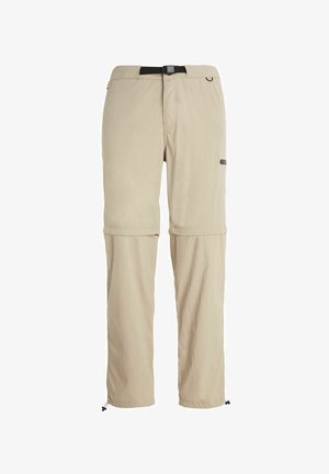 Beige afneembare broek gemaakt van lichtgewicht stof, met een verstelbare tailleband, zijzakken en koordjes bij de pijpen voor een aanpasbare pasvorm.