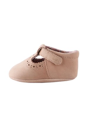Zachte beige babyschoen met klittenbandsluiting en hartvormige uitsnijdetails, gevoerd met bloemenstof op een witte achtergrond.